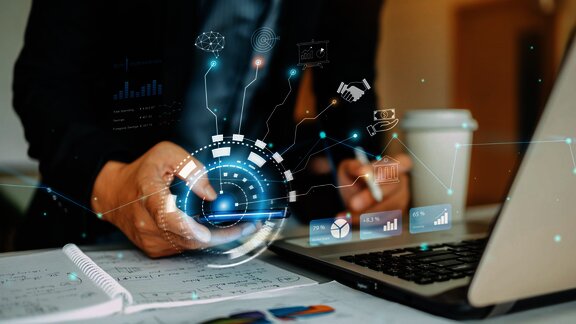 Osoba koristi laptop sa digitalnim ikonama i grafovima_Rox