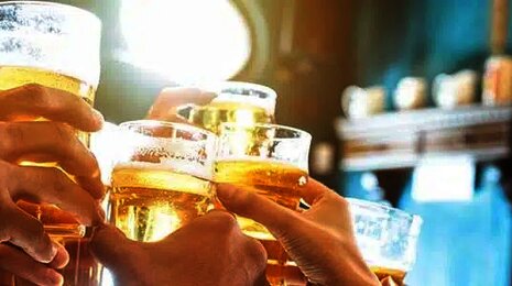 Hands holding beers coming together in the air