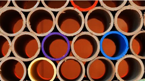 Stacked tubes with colored interiors forming circular patterns, symbolizing diversity and structure