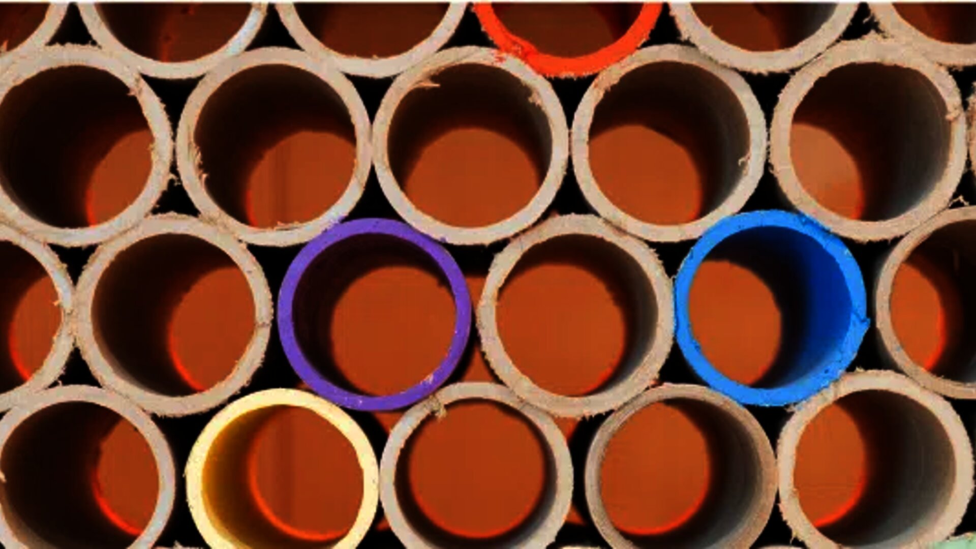 Stacked tubes with colored interiors forming circular patterns, symbolizing diversity and structure