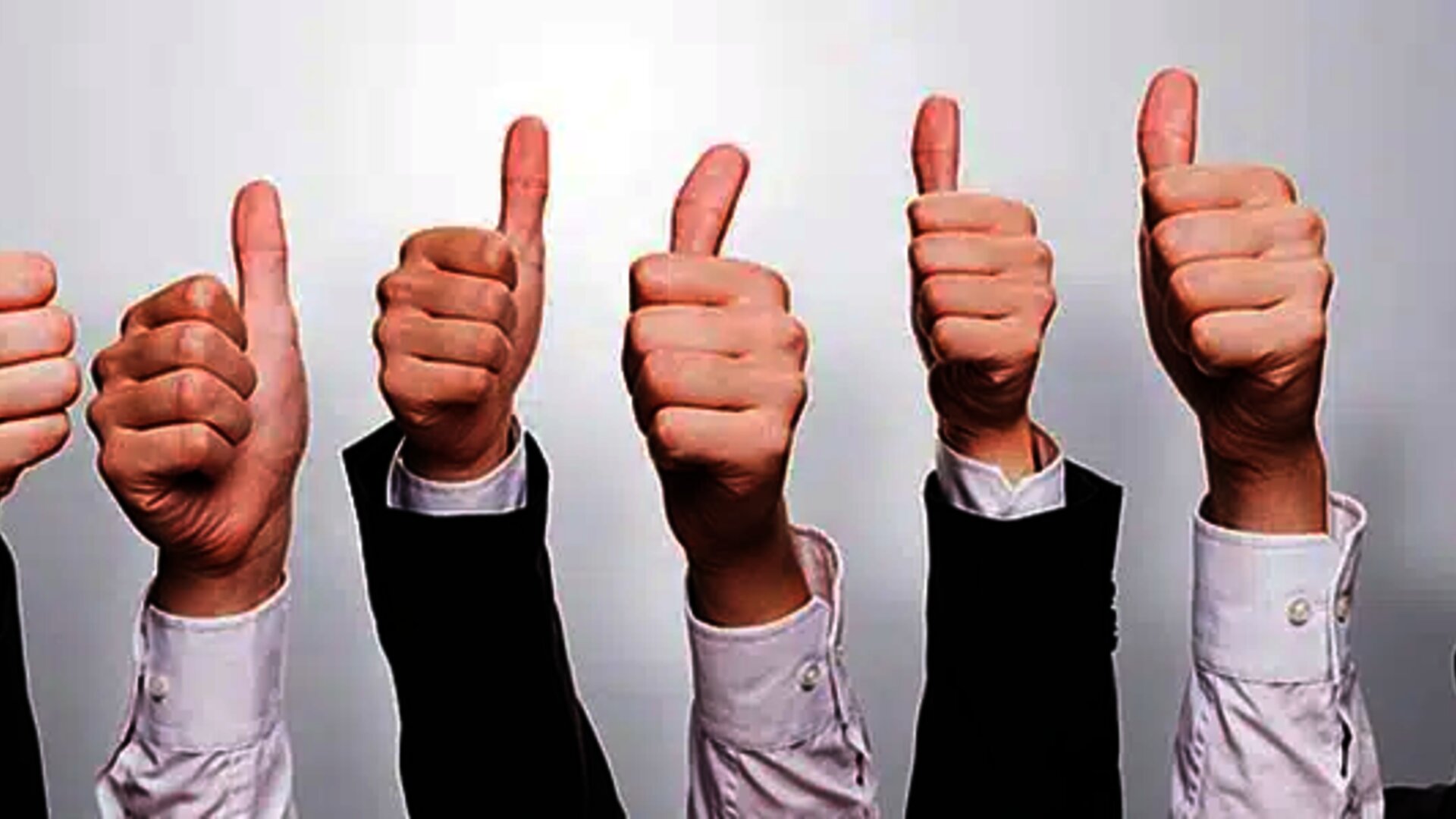Hands in business attire giving thumbs-up, symbolizing approval, success, or positive feedback