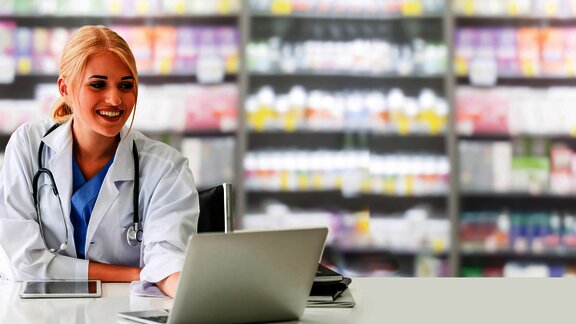 Ženska osoba, farmaceut pred laptopom u ljekarni