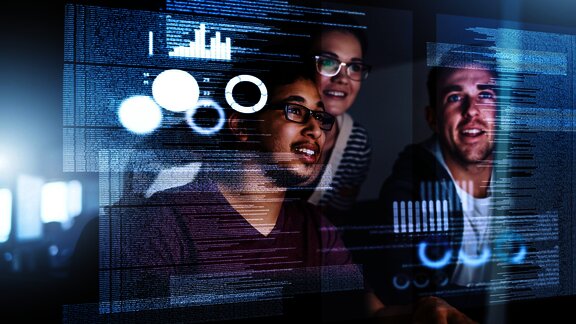 A group of young professionals collaborating in front of a computer screen, with overlaid digital data, code, and charts, symbolizing teamwork in programming and data analysis