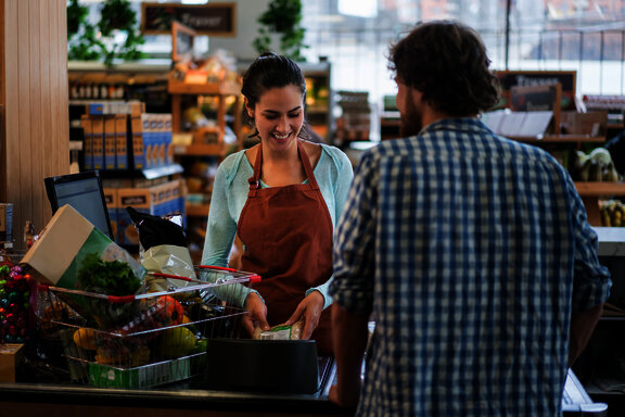 man is paying for the goods at the supermarket